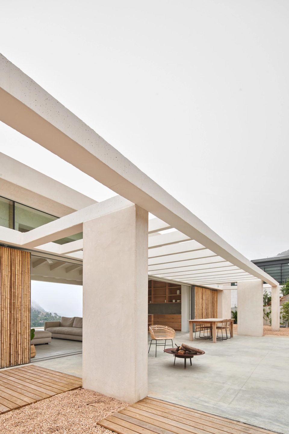 The outdoor spaces of this single-family home have been designed as a natural continuation of the interior, creating open, protected areas fully connected to the landscape. The large pergola structure generates a light and geometric architecture that filters natural light and adds visual depth to the living spaces. Natural materials such as wood and mineral finishes reinforce the Mediterranean character of the home and establish a harmonious relationship with the surroundings. This single-family home combines contemporary design, spaciousness, and landscape integration to create an open, bright living experience focused on outdoor comfort.