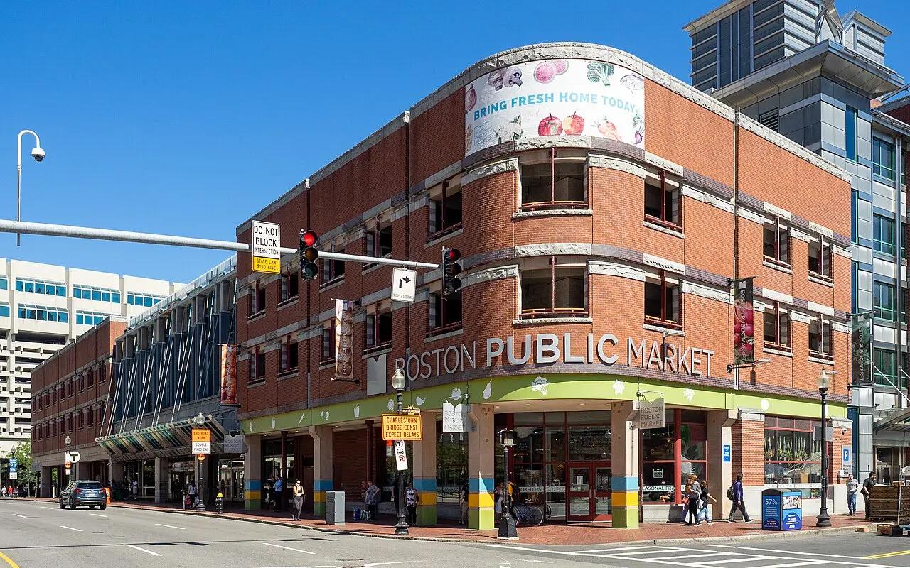 The brick Boston Public Market building at Hanover and Congress streets under a clear blue sky