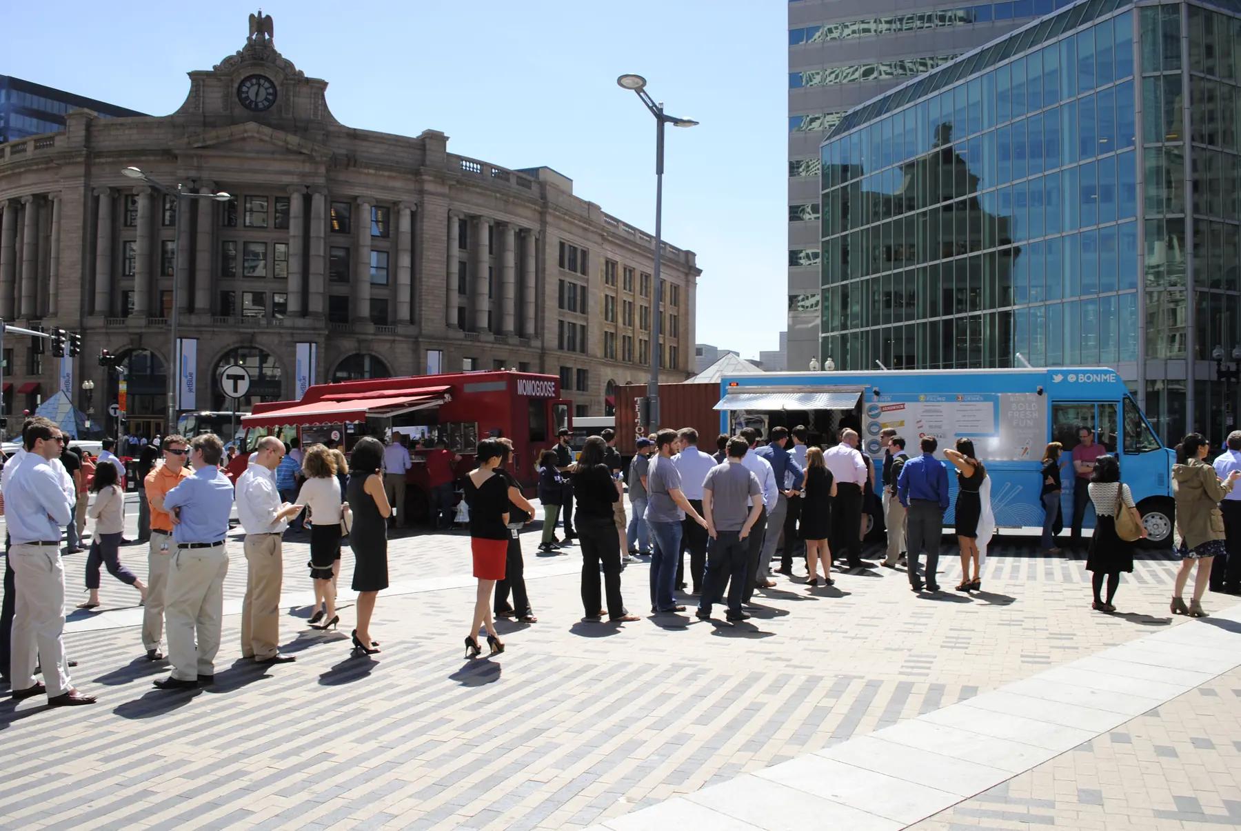 People lining up at food trucks beside Dewey Square in downtown Boston