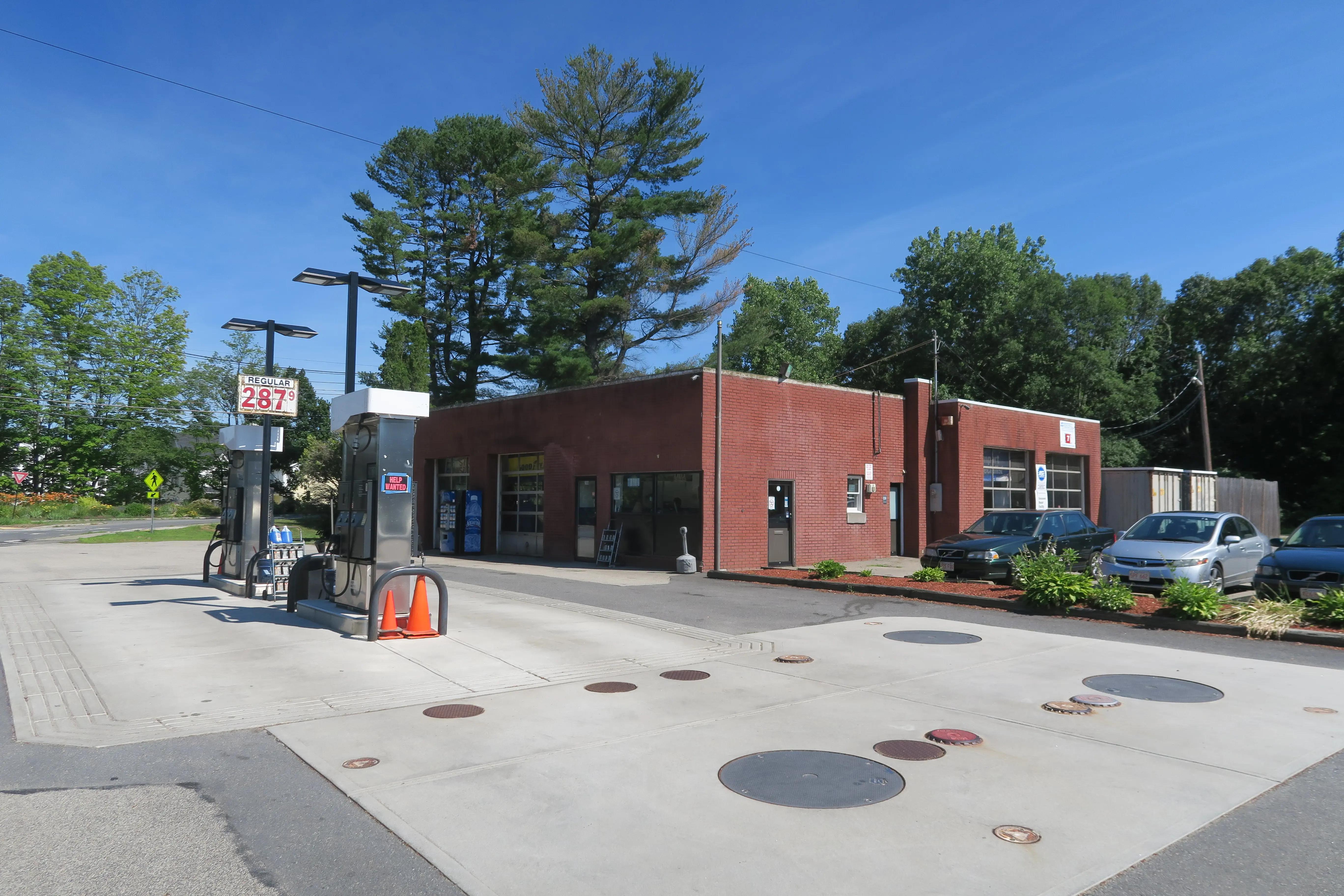 Cars outside Sudbury Automotive in Massachusetts, with inspection signage above a garage bay