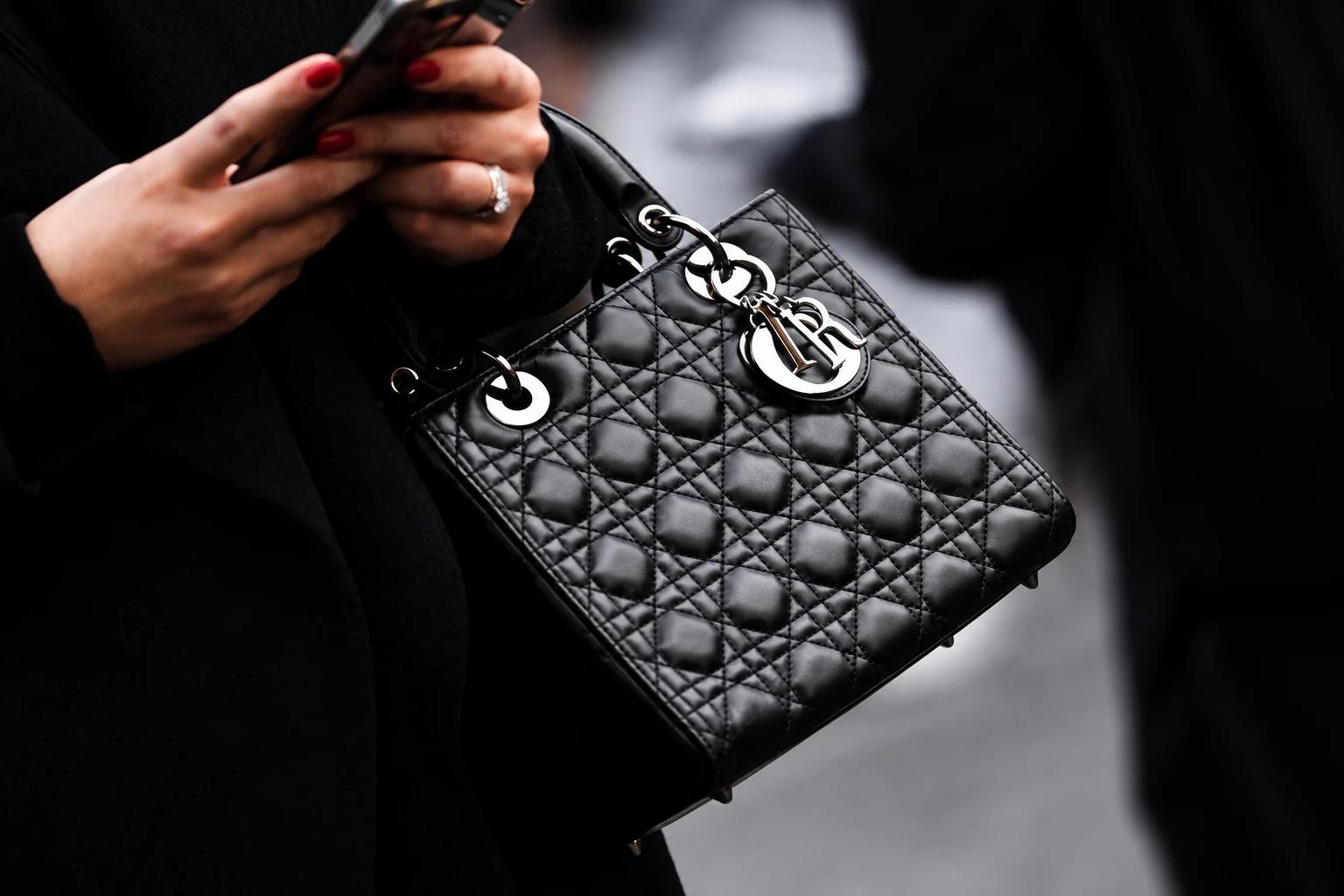 A black quilted leather Dior handbag carried on the arm