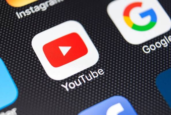 Close-up of YouTube app icon on smartphone screen with Instagram and Google icons visible