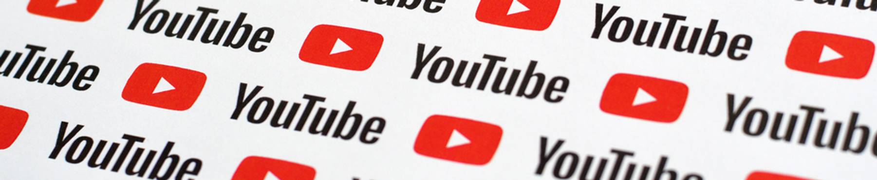 Pattern of red YouTube play button logos and black YouTube text on white background
