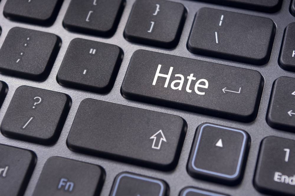 Close-up of a computer keyboard with a key labeled "Hate" replacing the Enter key.