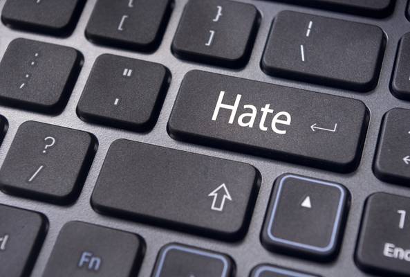 Close-up of a computer keyboard with a key labeled "Hate" replacing the Enter key.