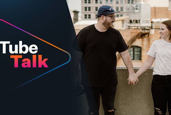 Tube Talk logo beside a smiling couple holding hands outdoors in an urban setting