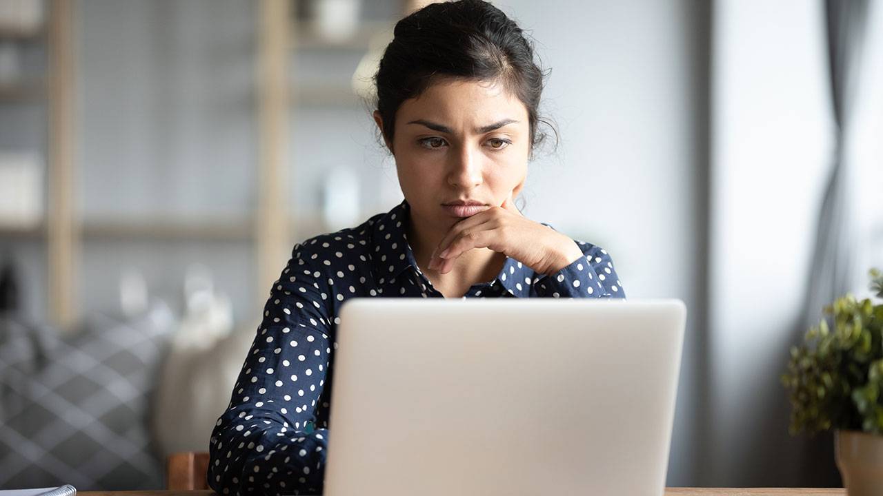A woman frowning at her laptop