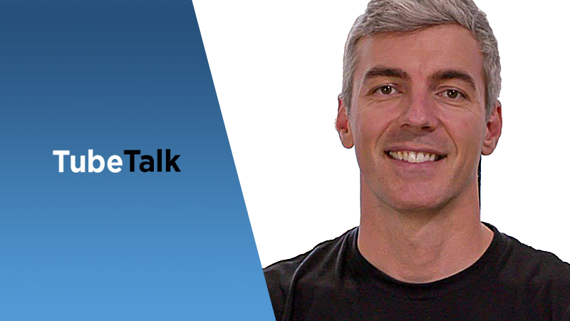 Smiling man with gray hair next to blue TubeTalk logo on white background