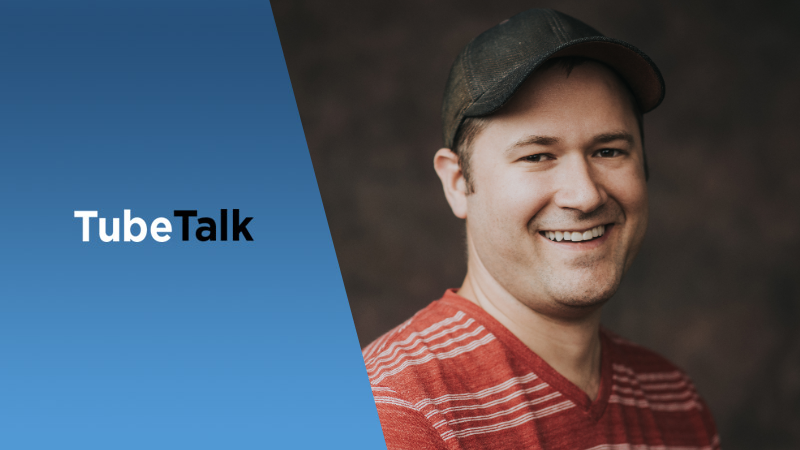Smiling man in red striped shirt and cap with TubeTalk logo on blue background