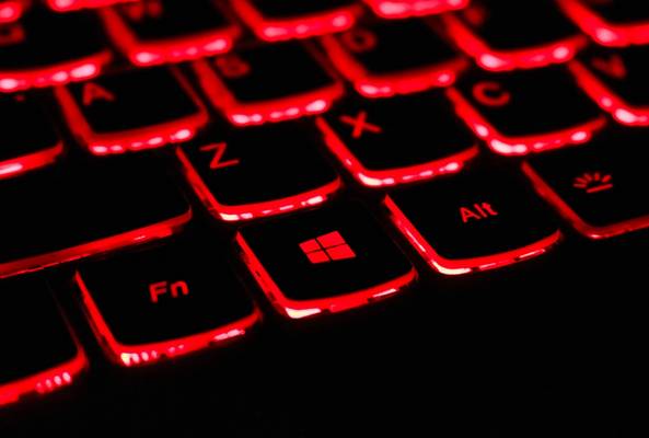 Close-up of a red backlit gaming keyboard with Windows and function keys visible