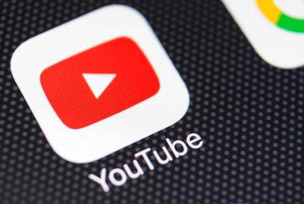 Close-up of YouTube app icon on smartphone screen with other social media icons visible