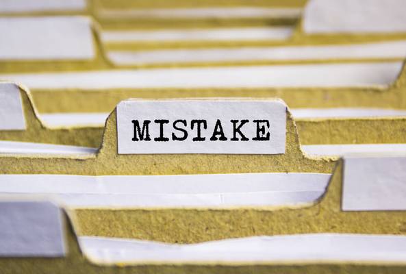 Close-up of a file folder labeled "MISTAKE" among other blank folders for organization.