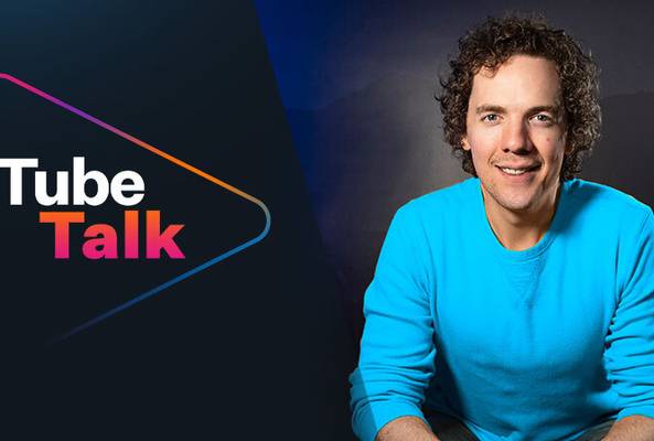 Man in blue shirt next to Tube Talk logo on dark background for video podcast.