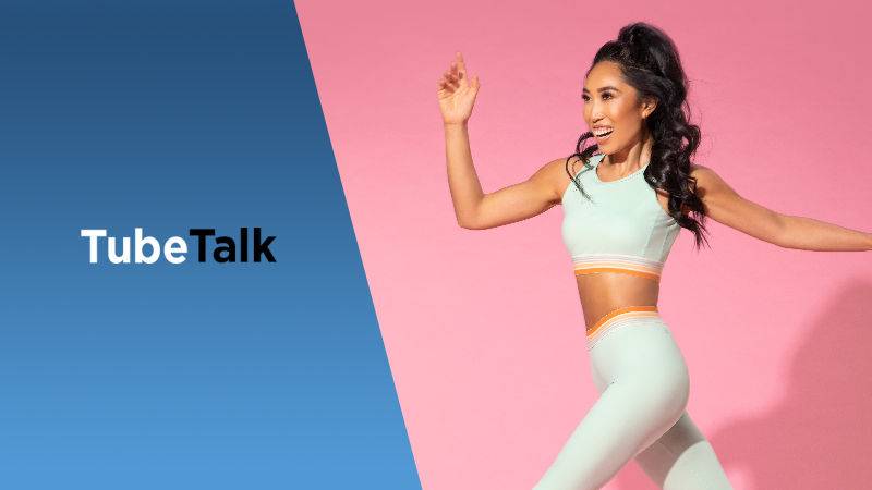 Smiling woman in activewear jumping with TubeTalk logo on blue and pink background