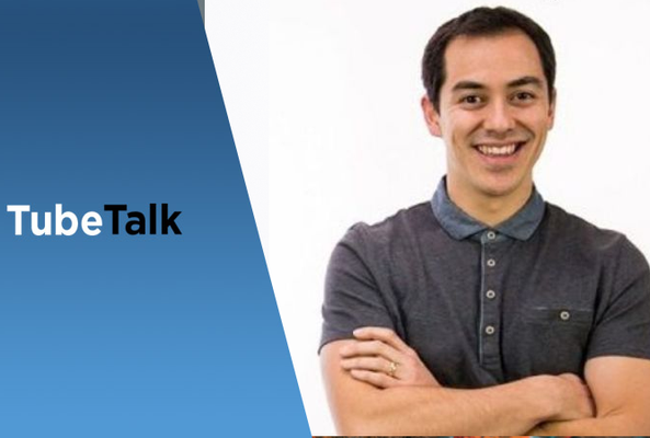 Smiling man in gray polo shirt with TubeTalk blue and white logo on left side background