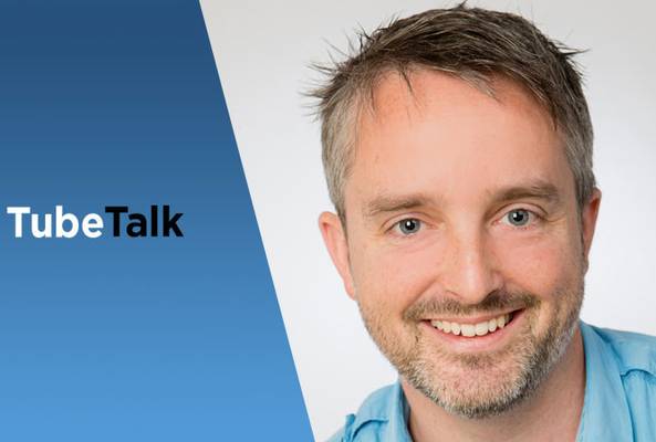 Smiling man in blue shirt with TubeTalk logo on blue and white background