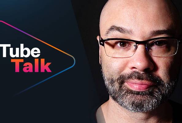 Tube Talk logo with a bearded man wearing glasses on a dark background