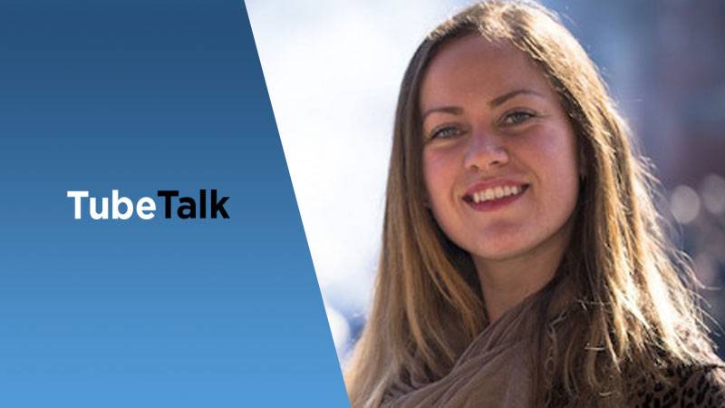 Smiling woman next to blue panel with TubeTalk logo, video communication concept