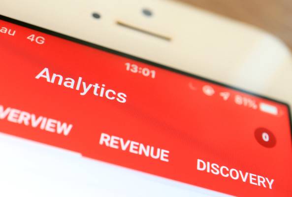 Mobile screen showing analytics app with overview, revenue, and discovery tabs visible.