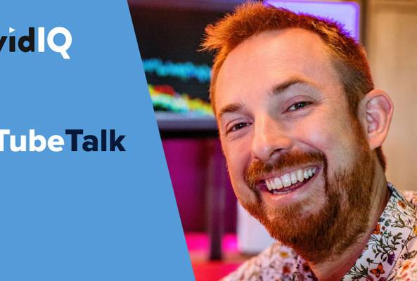 Smiling man with beard in front of computer screen, vidIQ TubeTalk branding on blue background