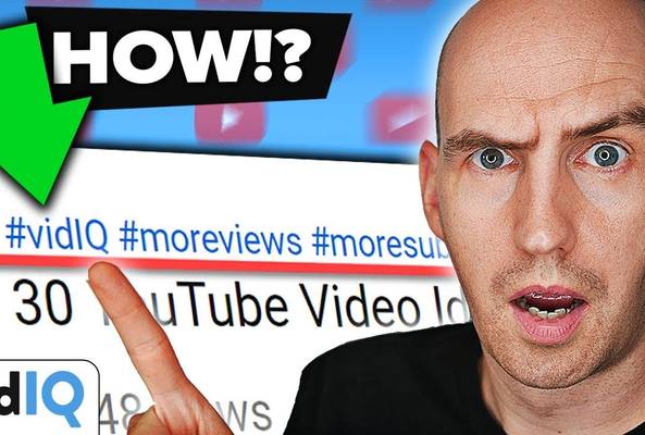 Man pointing at YouTube hashtags #vidIQ, #moreviews, #moresubs with surprised expression.