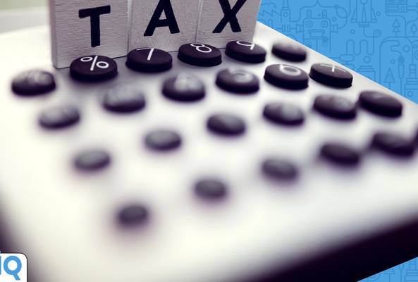 Calculator buttons with wooden blocks spelling TAX and percent sign, finance concept.