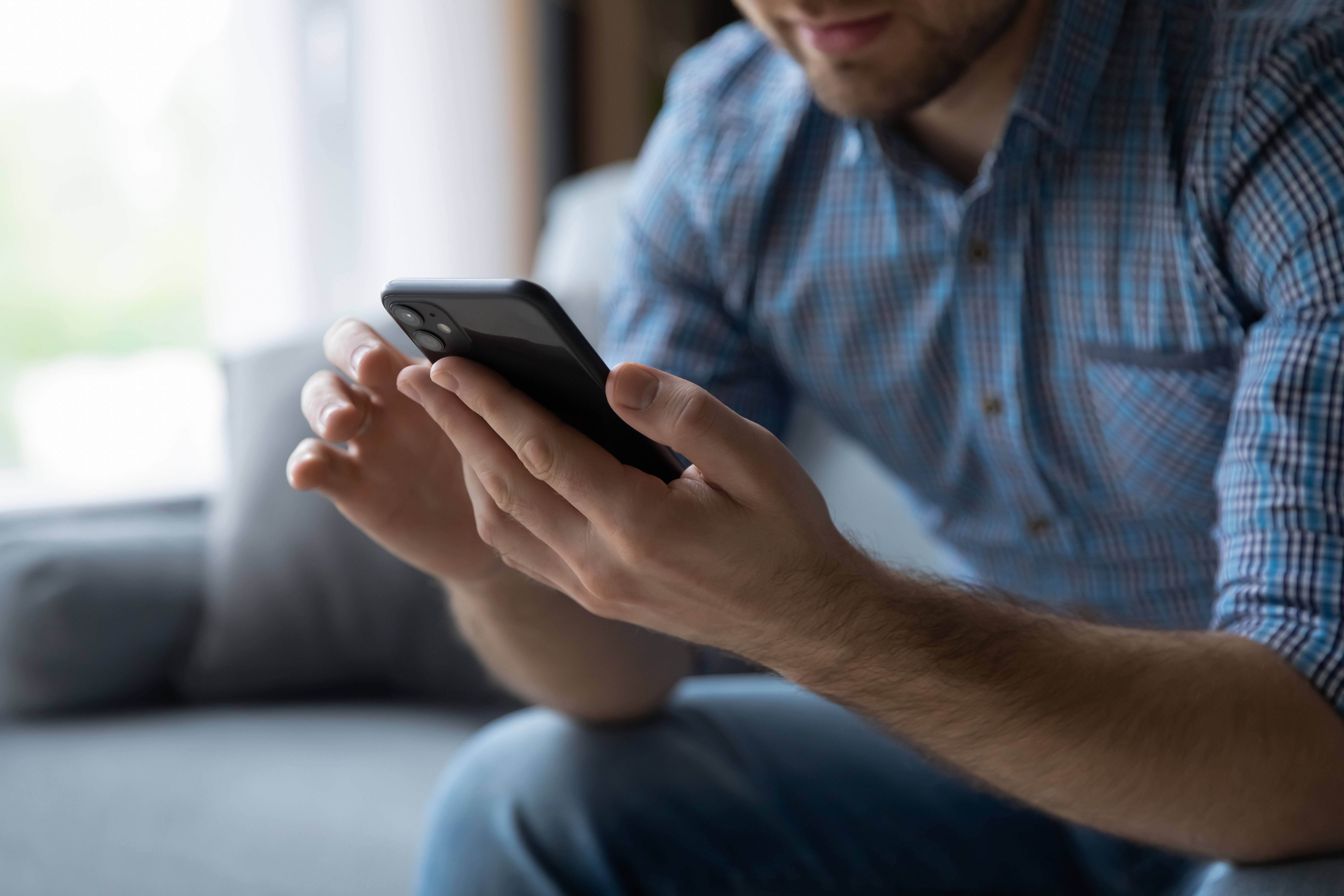 man holding a smartphone, symbolizing mobile-first video engagement.