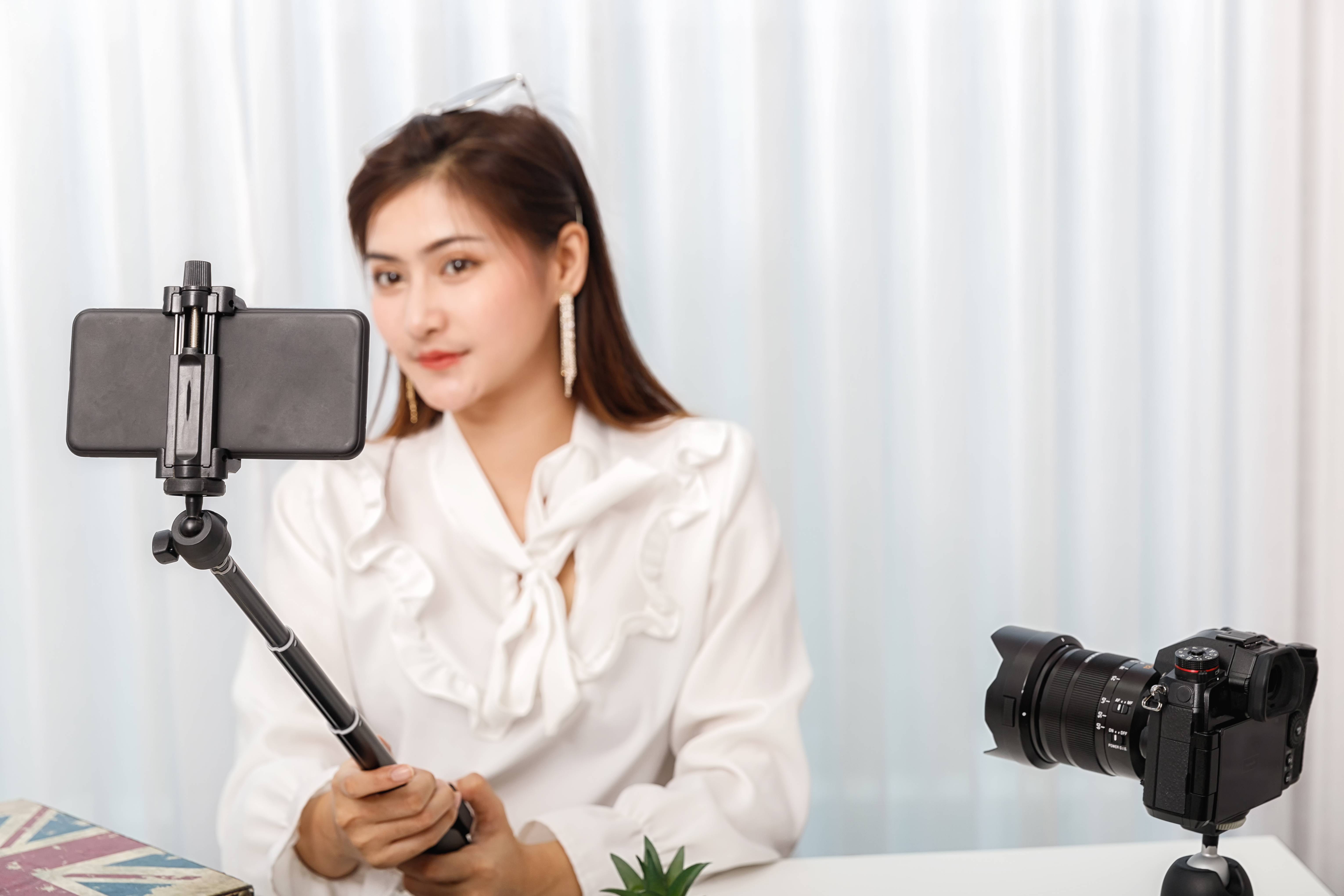 Woman filming content with both phone and camera