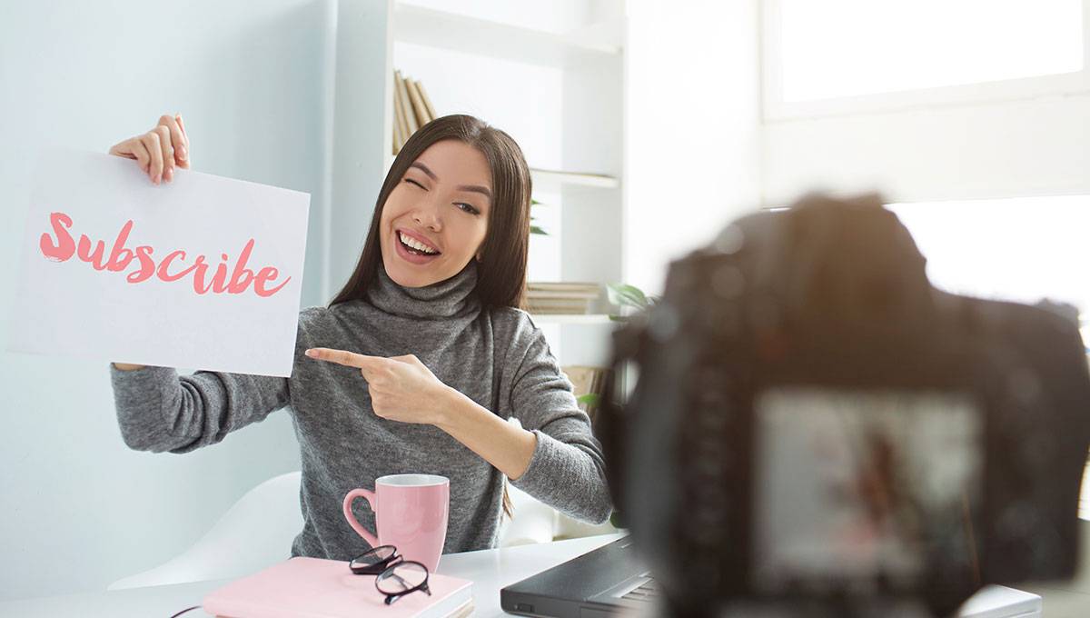 Creator holding a subscribe sign