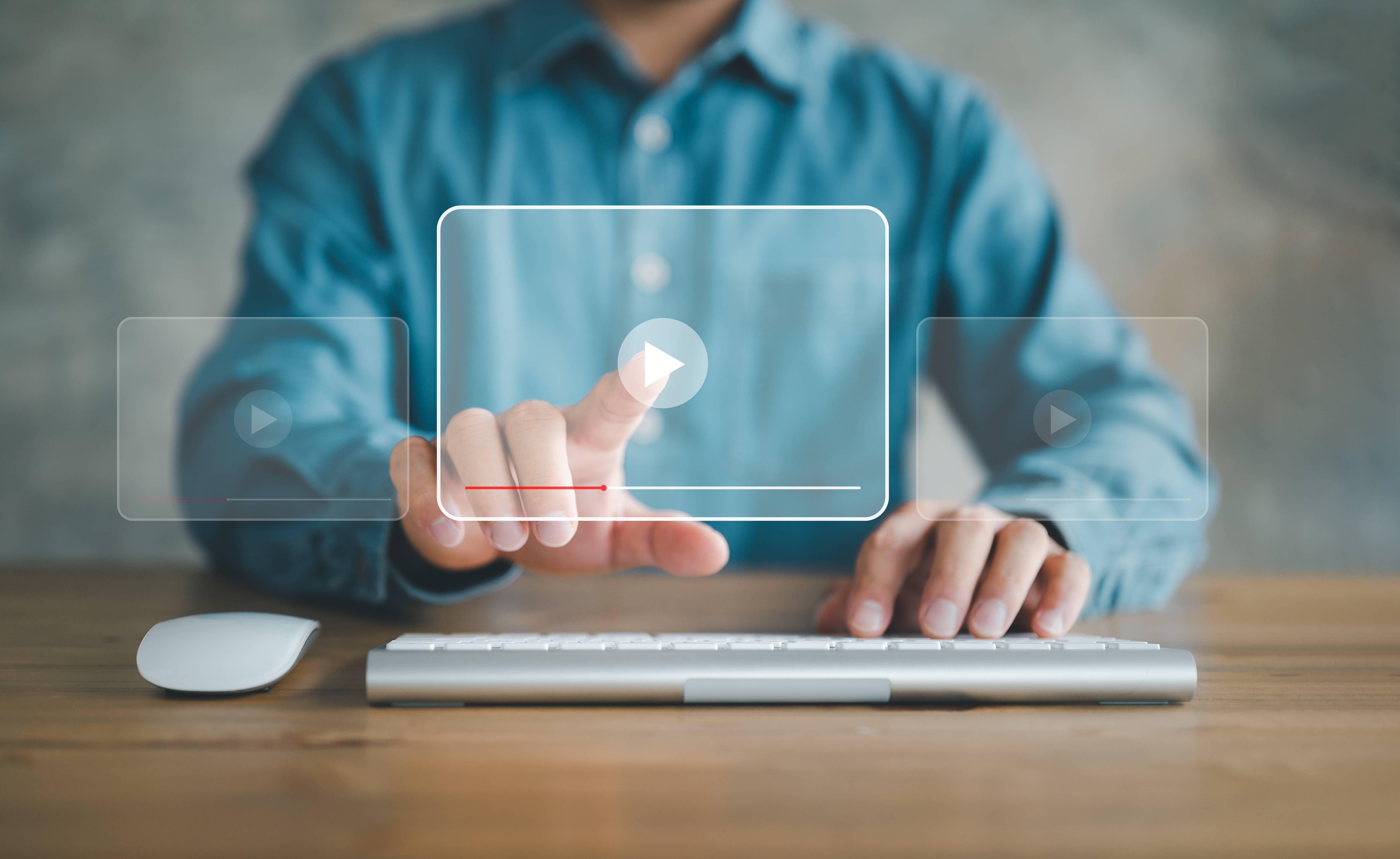 man tapping on screen to play video
