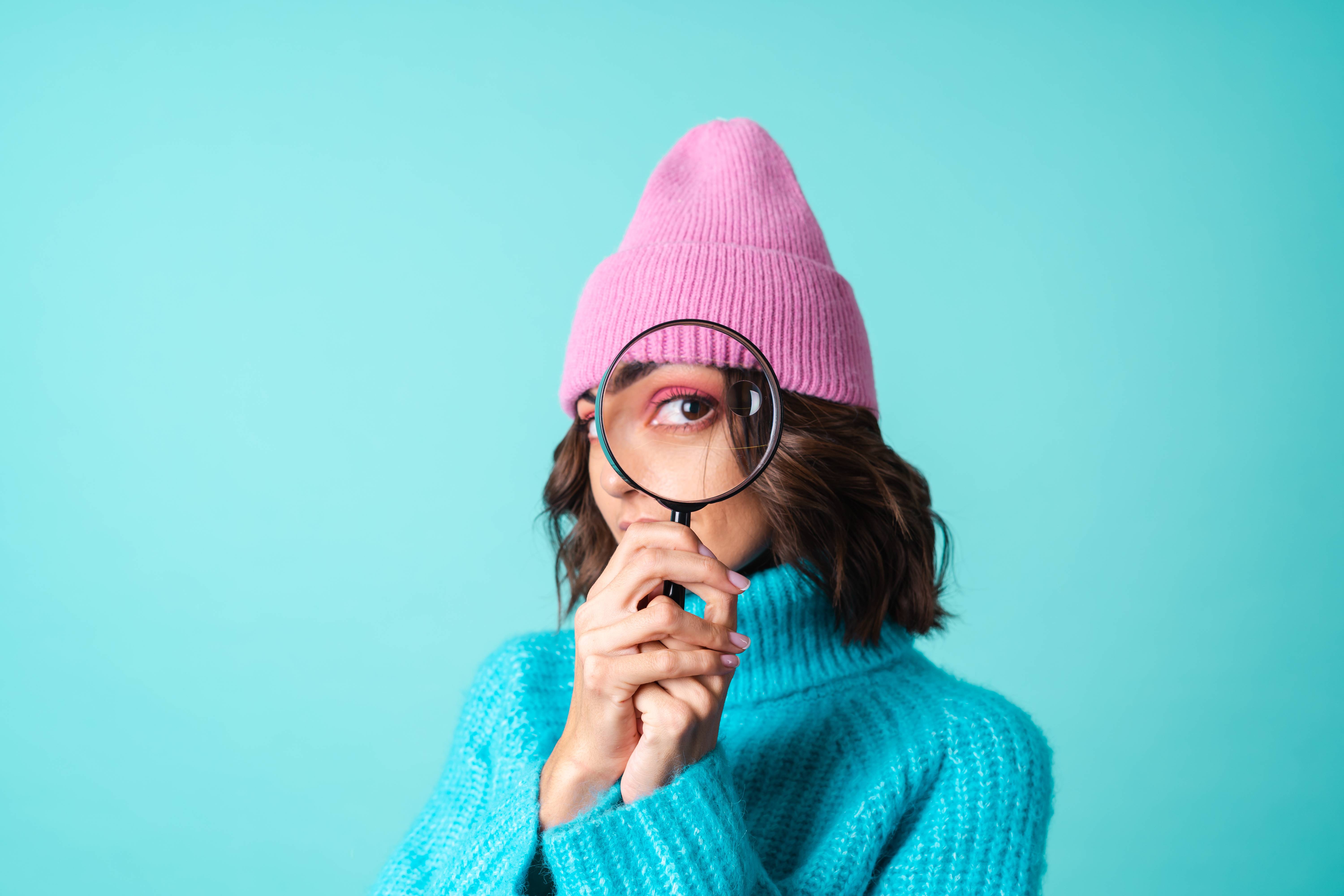 Woman looking through a magnifying glass