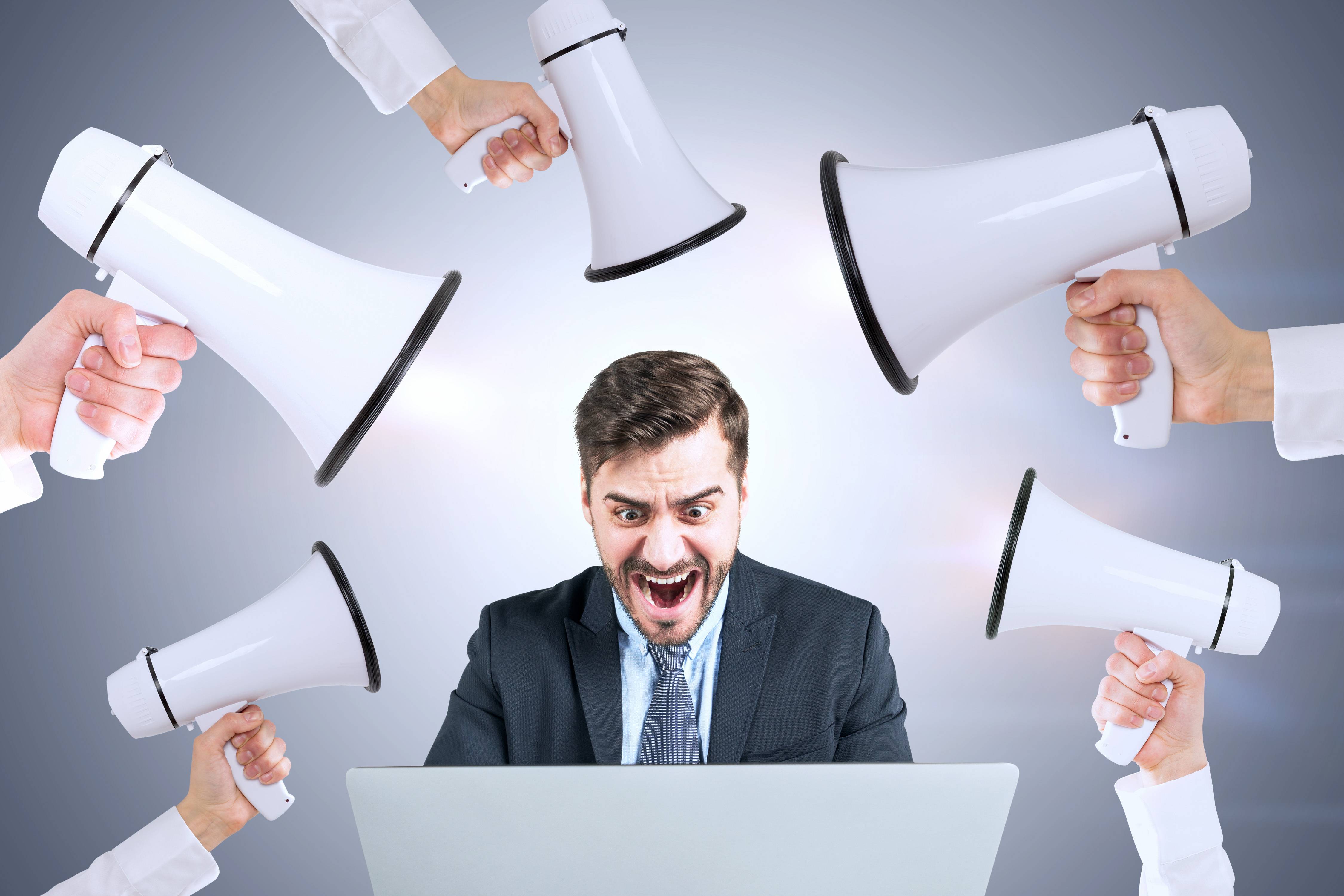 Man being surrounded by megaphones