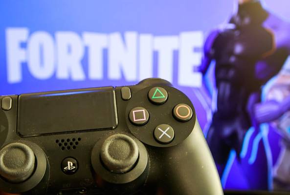 Close-up of PlayStation controller with blurred Fortnite game screen in background