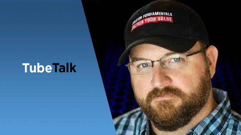 Close-up of man with glasses and cap beside TubeTalk logo on blue and black background