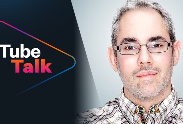 Tube Talk logo with a man wearing glasses, promoting video content discussion.