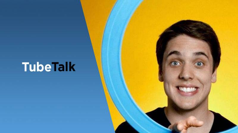 Smiling man holding blue ring with TubeTalk logo on blue and yellow background.