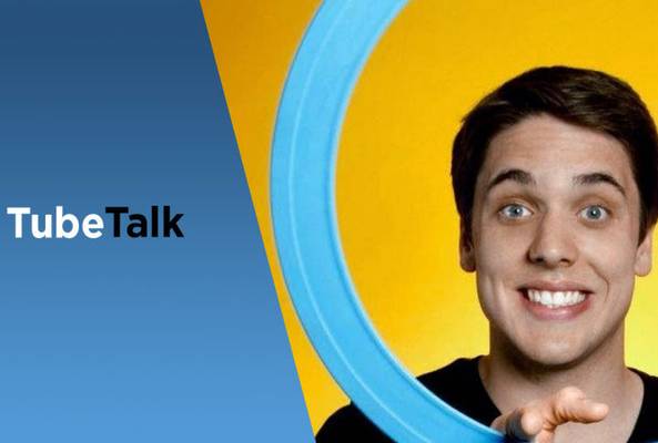 Smiling man holding blue ring with TubeTalk logo on blue and yellow background.