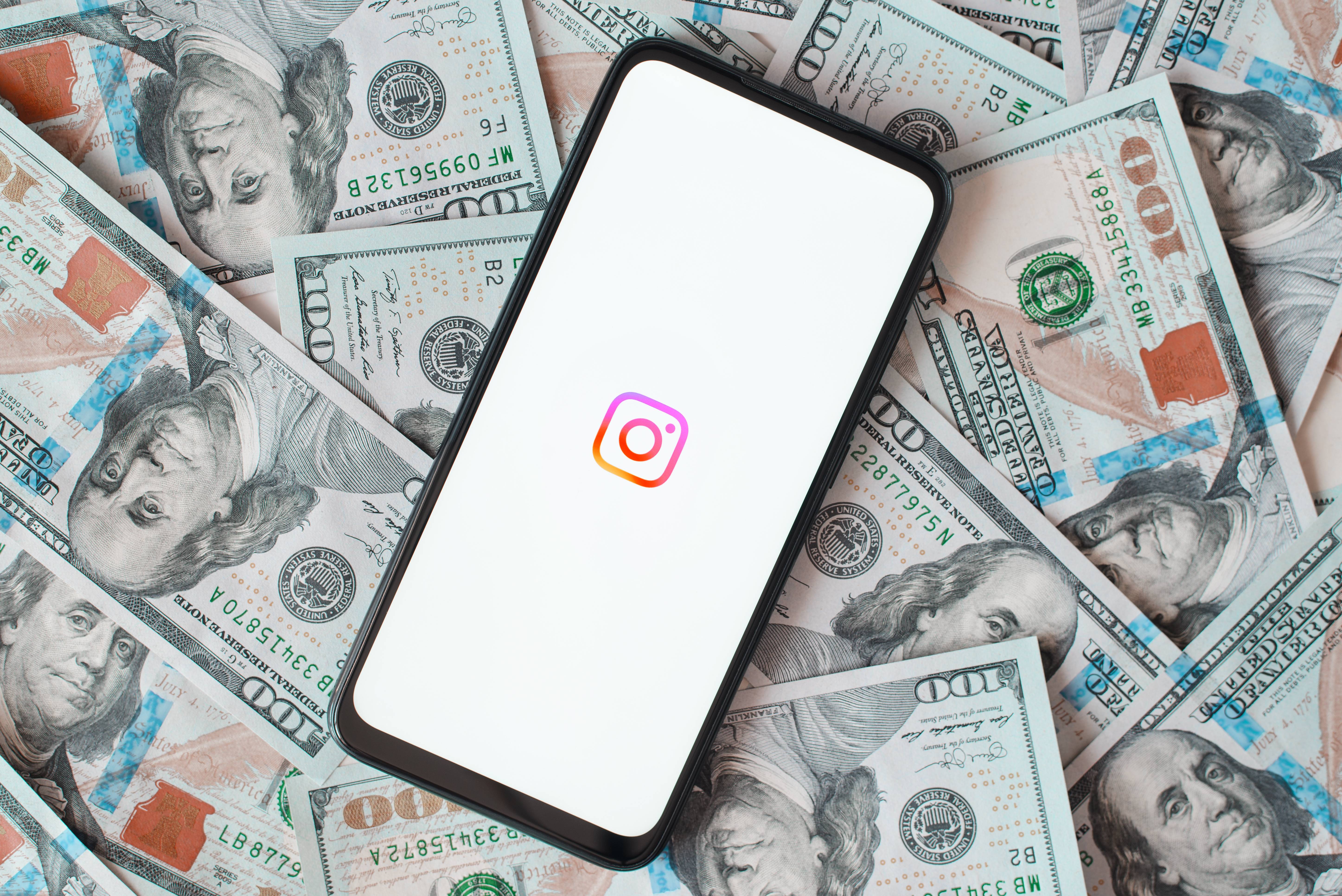 Instagram logo on phone with currency in background