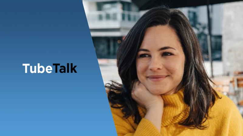 Young woman in yellow sweater smiling, TubeTalk logo on blue background beside her