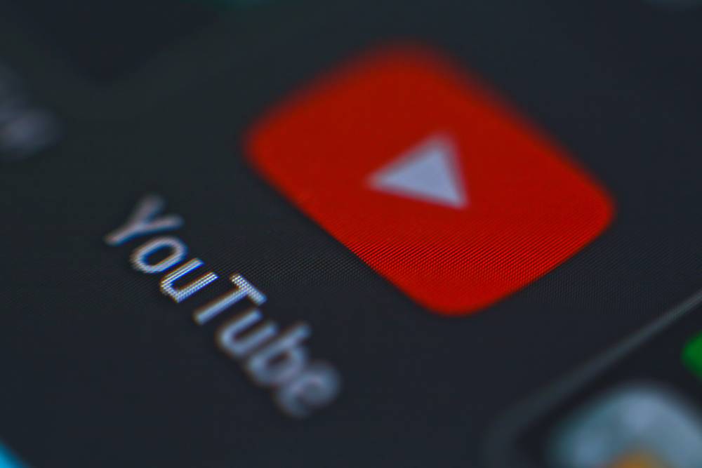 Close-up of YouTube app icon on a smartphone screen, focusing on logo and text.