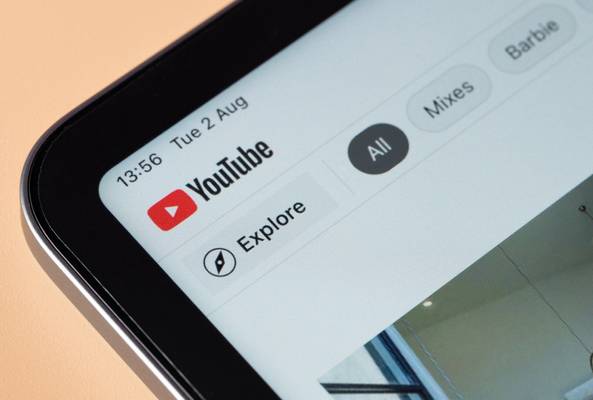 Close-up of YouTube app interface showing Explore and video category filters on tablet screen