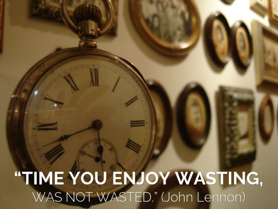 Close-up of vintage pocket watch with John Lennon quote about time on a wall background
