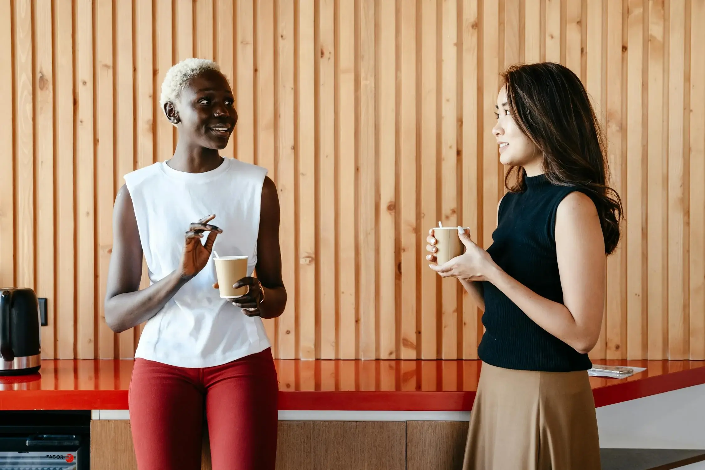 Two woman holding a cup