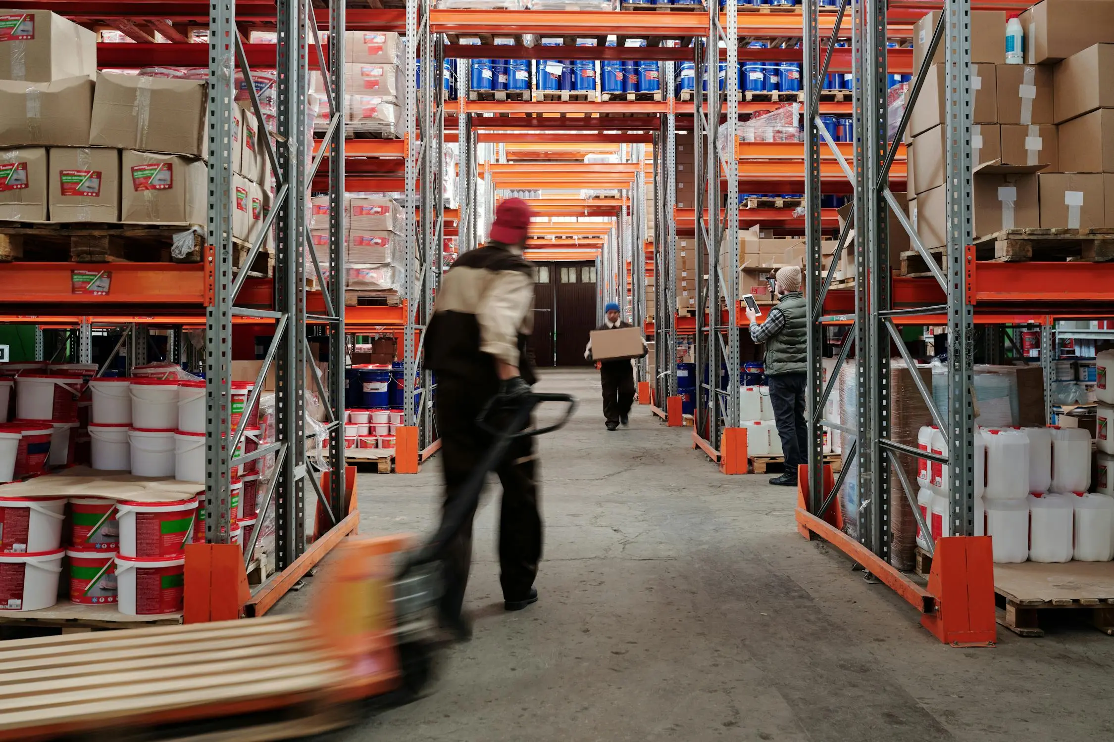 A man pulling a cart in a factory