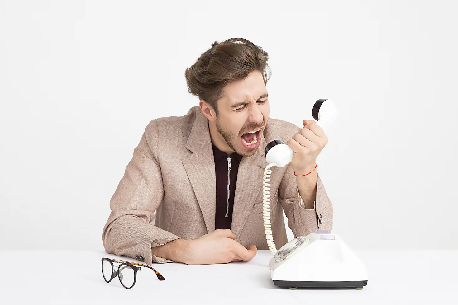 A man shouting on a telephone