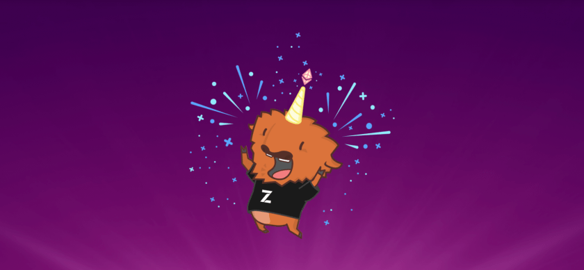 Cheerful orange mascot character wearing a party hat and black shirt, laughing with arms raised amid colorful starbursts on purple background.