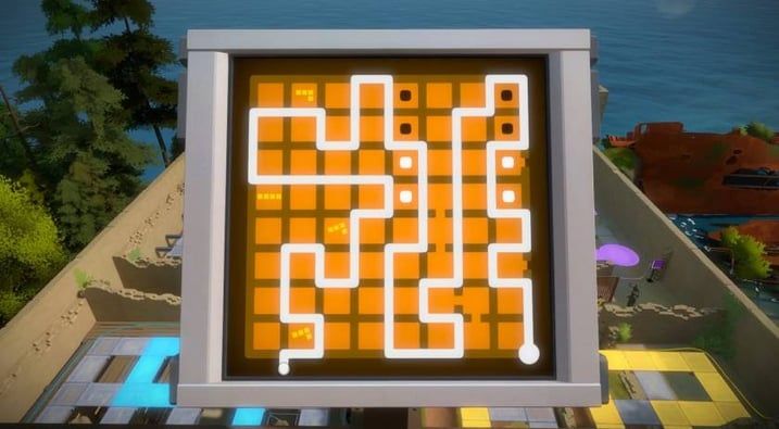 Illuminated yellow and white maze game displayed on a wall overlooking a coastal resort area.