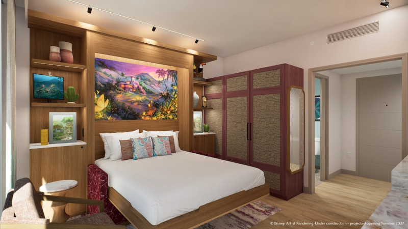 The image depicts a modern guest room within a lodge, featuring stylish wooden furniture and vibrant artwork. The room is designed with a warm color palette and includes a bed, decorative pillows, and artistic shelving with various decorative items.