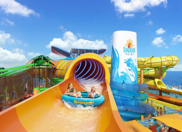 The image depicts a colorful water slide complex at a tropical water park, featuring a large slide that spirals into a pool. Families and children are enjoying the attractions on a sunny day.