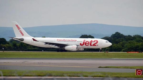 The image features a Jet2 airline aircraft on the runway, preparing for takeoff. The plane is prominently displaying the Jet2 logo and slogan 'Friendly Low Fares,' indicative of the airline's focus on budget travel.